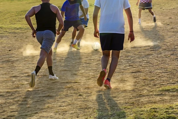 Jonge jongens spelen van de voetbalwedstrijd op de zonsondergang — Stockfoto
