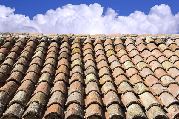 Tejas viejas, cielo azul y nubes en el fondo Imagen De Stock