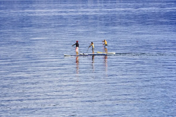 Unga människor paddling tillsammans i havet — Stockfoto
