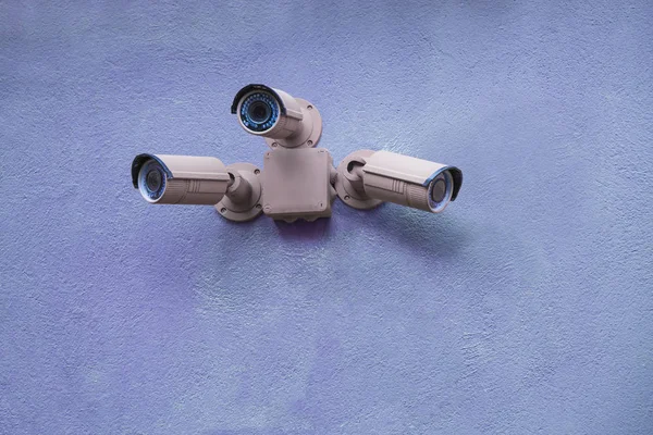 Trois caméras de sécurité sur le mur bleu — Photo