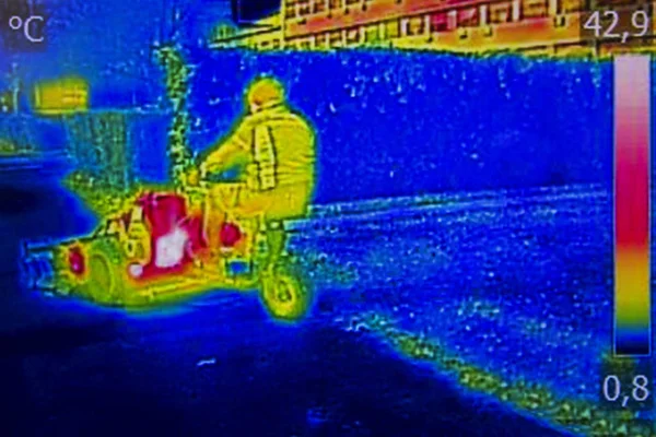 Infrared Thermal image worker cutting grass in city park — Stock Photo, Image