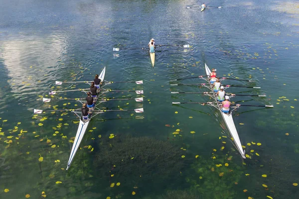 Молодые спортсмены гребут на спокойном озере — стоковое фото