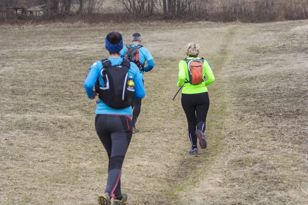 Två kvinnor och en man jogging och kör utomhus i naturen — Stockfoto