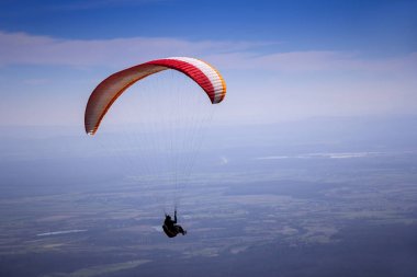 Paraglider mavi yaz gökyüzünde uçar