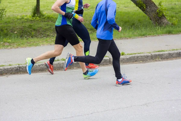 Марафон біжить трьома бігунами по міській дорозі — стокове фото