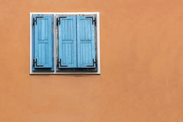 Blue wooden window shutters on the orange facade — Stock Photo, Image