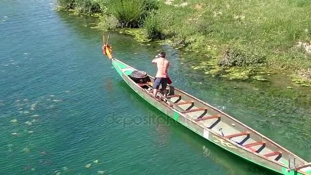 Uomo in piedi a prua remare la barca di legno — Video Stock