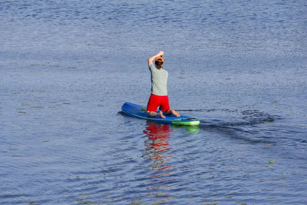 Hombre en la tabla de remo remando hacia el lago —  Fotos de Stock