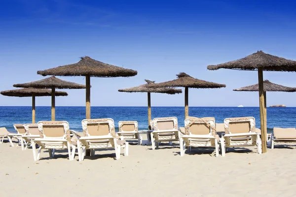 Sillas y sombrillas en una hermosa playa de arena en Ibiza —  Fotos de Stock
