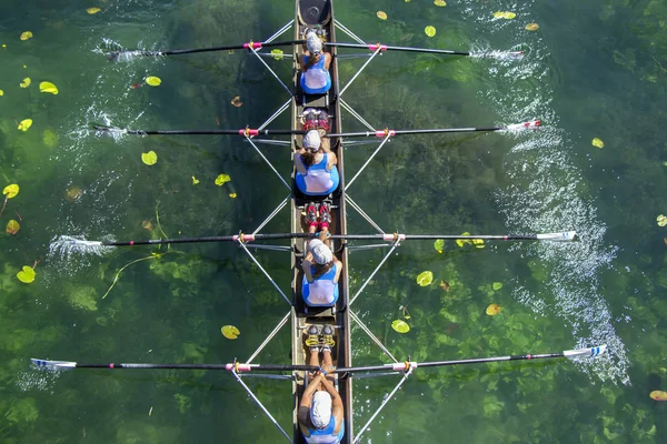 Дамы, четверо гребцов команды в гонке на озере — стоковое фото
