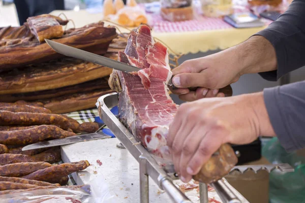 Corte de presunto curado a seco prosciutto no mercado de rua — Fotografia de Stock