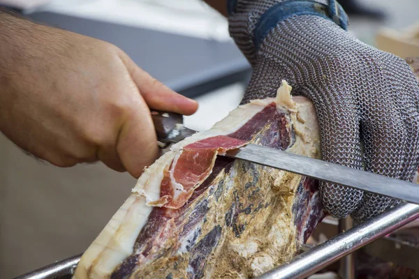 Corte de presunto curado a seco prosciutto no mercado de rua — Fotografia de Stock