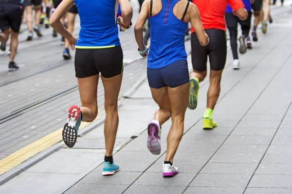 Corredores de maratón corren en las calles de la ciudad, movimiento borroso — Foto de Stock
