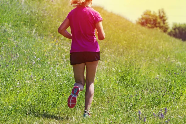 Mujer joven corriendo maratón al aire libre al atardecer — Foto de Stock