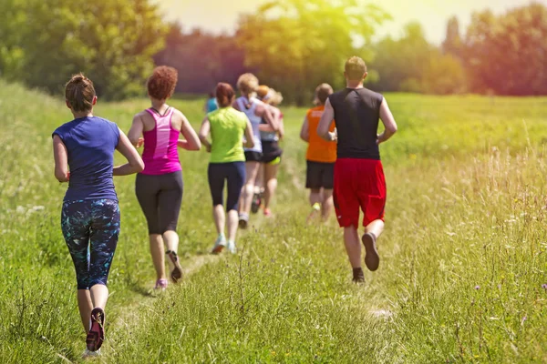 Groep van jonge atleet marathon buiten lopen in de zonsondergang — Stockfoto