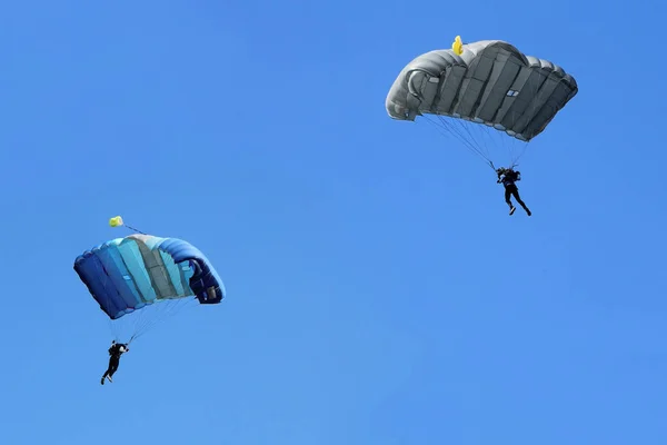 Два парашютиста летят в голубое небо — стоковое фото