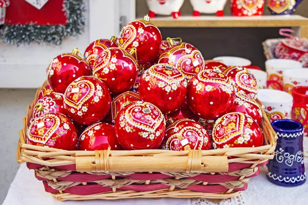 Bolas rojas de Navidad en canasta de mimbre, pintadas a mano con traditio —  Fotos de Stock