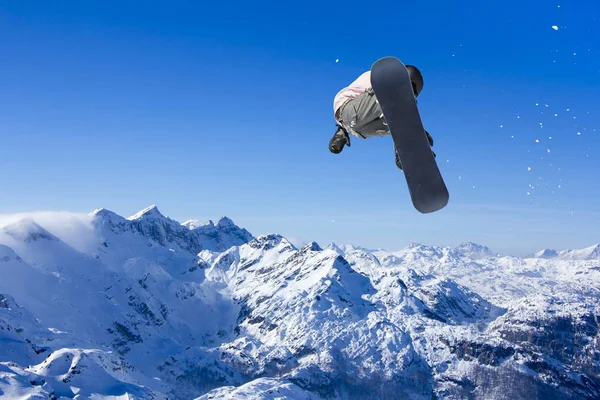 Skiër Snowboarder springt door de lucht met lucht op de achtergrond — Stockfoto