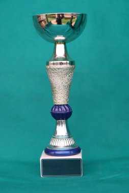 Yeşil arka planda yansıması olan şampiyon kupa.