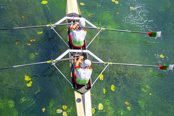 Dos jóvenes atletas remo equipo en el lago verde —  Fotos de Stock