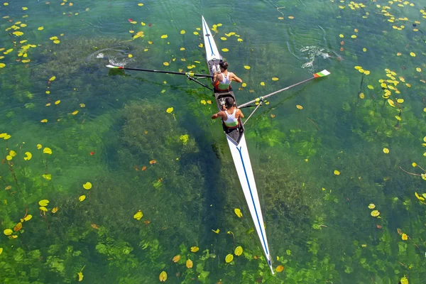 Two young athletes rowing team on green lake — Stock Photo, Image