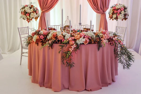 Krásně zdobený svatební stůl s květinami a svíčkami — Stock fotografie