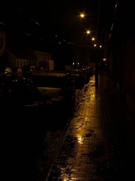 Foto Una Calle Con Coches Aparcados Por Noche Iluminada Solo —  Fotos de Stock