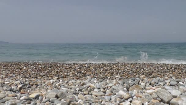 Linda água do mar limpa salpicando na costa de seixos — Vídeo de Stock