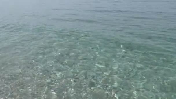 Linda água do mar limpa salpicando na costa de seixos — Vídeo de Stock