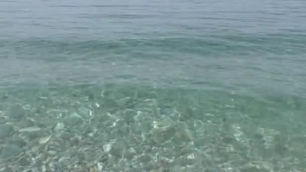 Linda água do mar limpa salpicando na costa de seixos — Vídeo de Stock