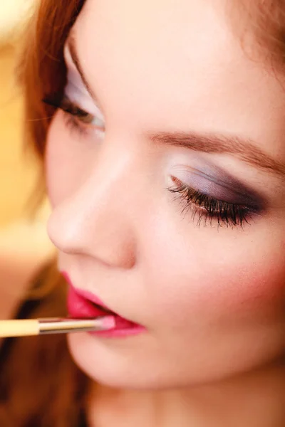 Deel van gezicht. Vrouw roze lippenstift met borstel toepassen — Stockfoto