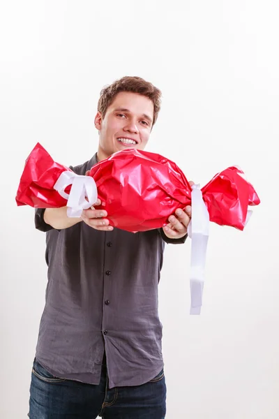 Uomo con grandi caramelle rosse . — Foto Stock