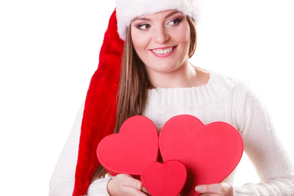 Mädchen Weihnachtsmann Helfermütze hält herzförmige Geschenkboxen — Stockfoto