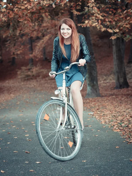 赤毛の女性が公園でサイクリング. — ストック写真