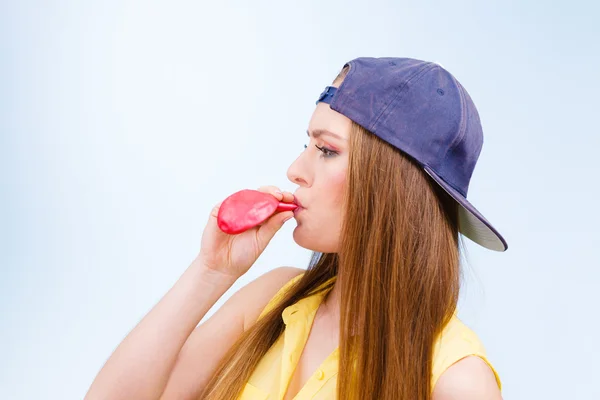 Adolescente menina soprando balão vermelho . — Fotografia de Stock