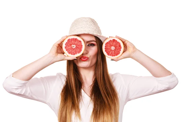 Menina cobrindo os olhos com duas metades de frutas cítricas de toranja — Fotografia de Stock