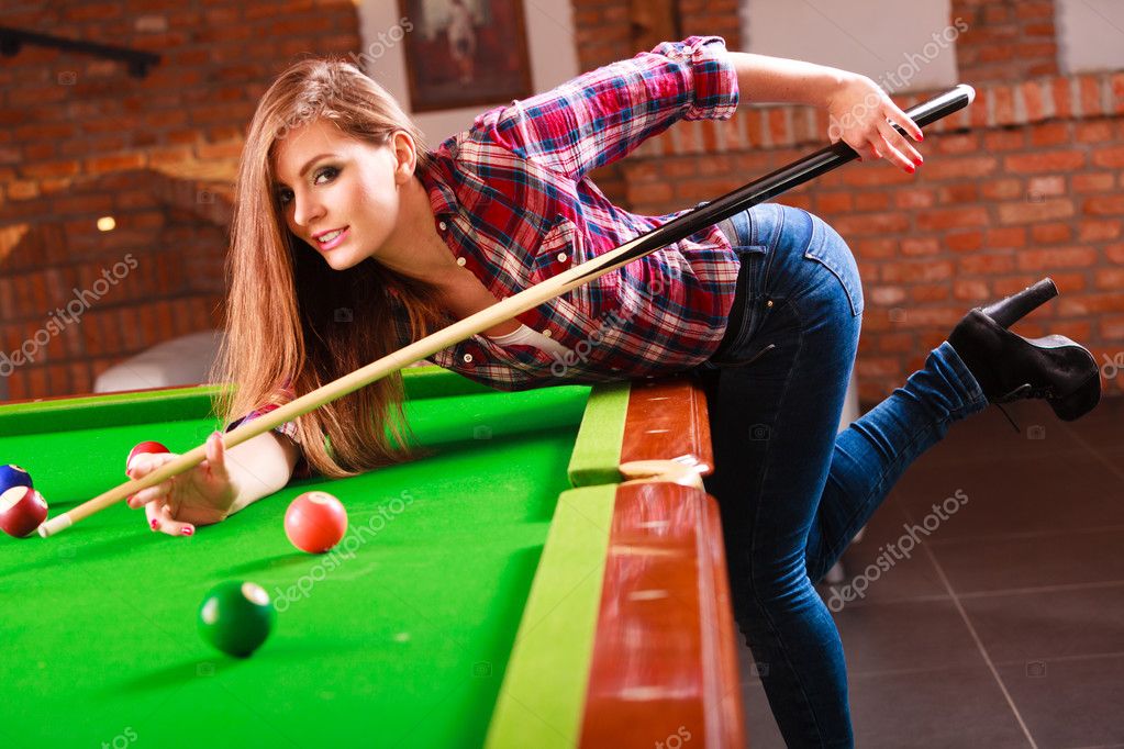 Young fashionable girl playing billiard. Stock Photo by Voyagerix