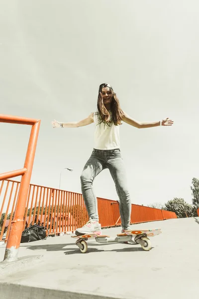 Dospívající dívka bruslař na koni skateboard na ulici. — Stock fotografie