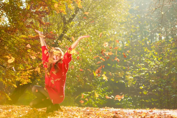 Krčící se dívka v autumském lese. — Stock fotografie