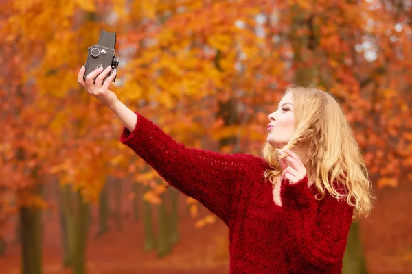Woman with old vintage camera taking selfie photo. — Stockfoto