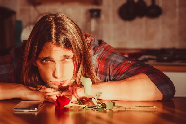 Orolig man med rose och mobiltelefon. — Stockfoto