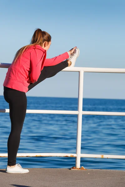 Woman doing sports exercises outdoors by seaside — Stock Photo, Image