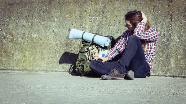 Man turist backpacker sitter av grunge vägg utomhus — Stockfoto
