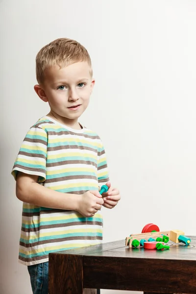 Kleiner Junge spielt mit Spielzeug auf Tisch. — Stockfoto