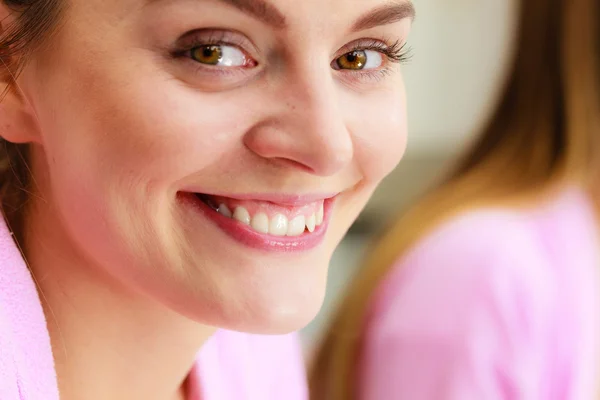 Young woman looking at mirror in bathroom — Stock Photo, Image