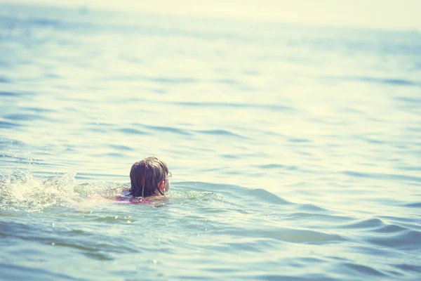 Een klein meisje dat in zeewater zwemt. Plezier — Stockfoto