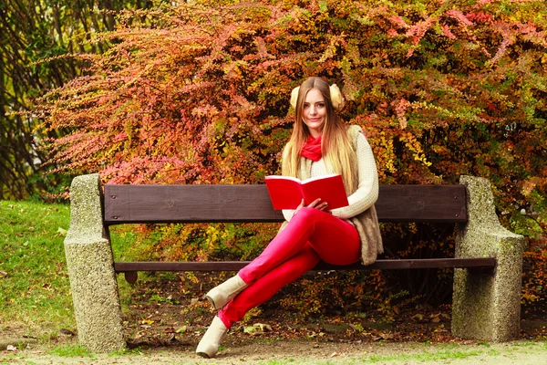 Frau entspannt sich im herbstlichen Park beim Lesen von Buch — Stockfoto