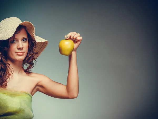 Woman in dress and hat hold yellow apple — Stock Photo, Image