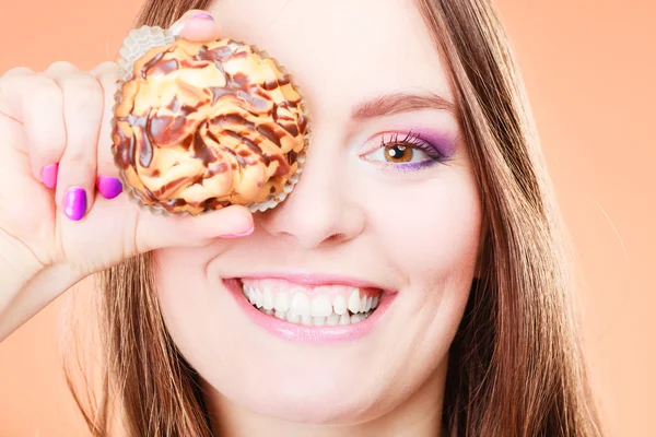 Lustige Frau hält Kuchen in der Hand und verdeckt ihr Auge — Stockfoto