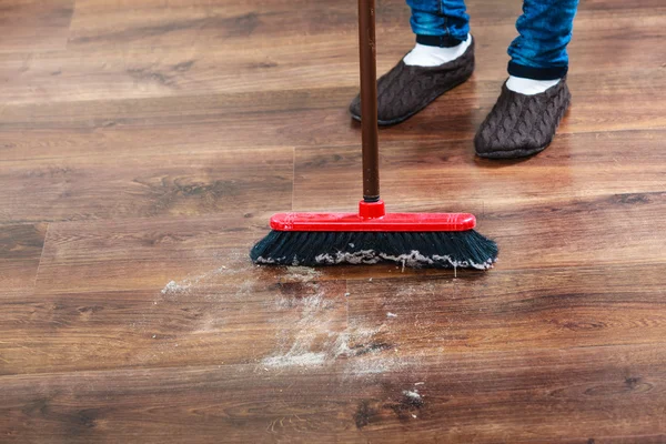 Limpeza mulher varrendo chão de madeira — Fotografia de Stock